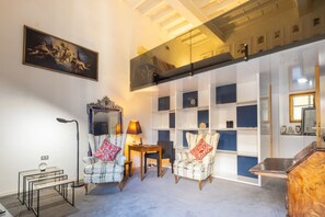 A room with a high ceiling, a large mirror, a chandelier, and a bookshelf. - Pitti Grand Retreat - Florence (Florence)