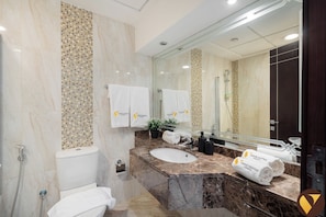 Une salle de bain moderne avec un meuble-lavabo en marbre, un grand miroir et des toilettes.