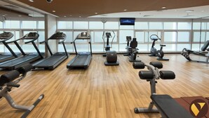 A gym with treadmills, elliptical machines, and weight benches. - Vogue | Siraj Tower Arjan near Miracle Garden (Dubai)