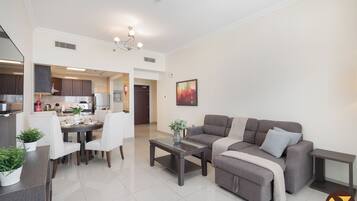 Luxury-Apartment, Balkon, Stadtblick | Wohnbereich | 65-Zoll-Smart-TV mit Kabelempfang