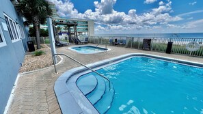 Ein Poolbereich mit zwei separaten Pools, einer überdachten Sitzgelegenheit und Blick auf den Ozean.