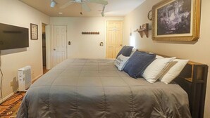 A bedroom with a bed, a ceiling fan, a radiator, and a framed picture on the wall. - 3 Mi to Angel Fire Resort! Quaint Apt on 2 Acres (Angel Fire)