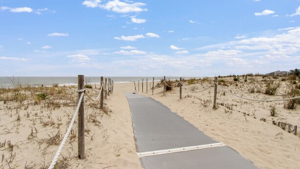 A sandy beach path leading to the ocean, with wooden posts and ropes marking the boundary. - NEW LISTING! Rehoboth by the Sea - Ocean Block - 19 Cullen St (Dewey Beach)