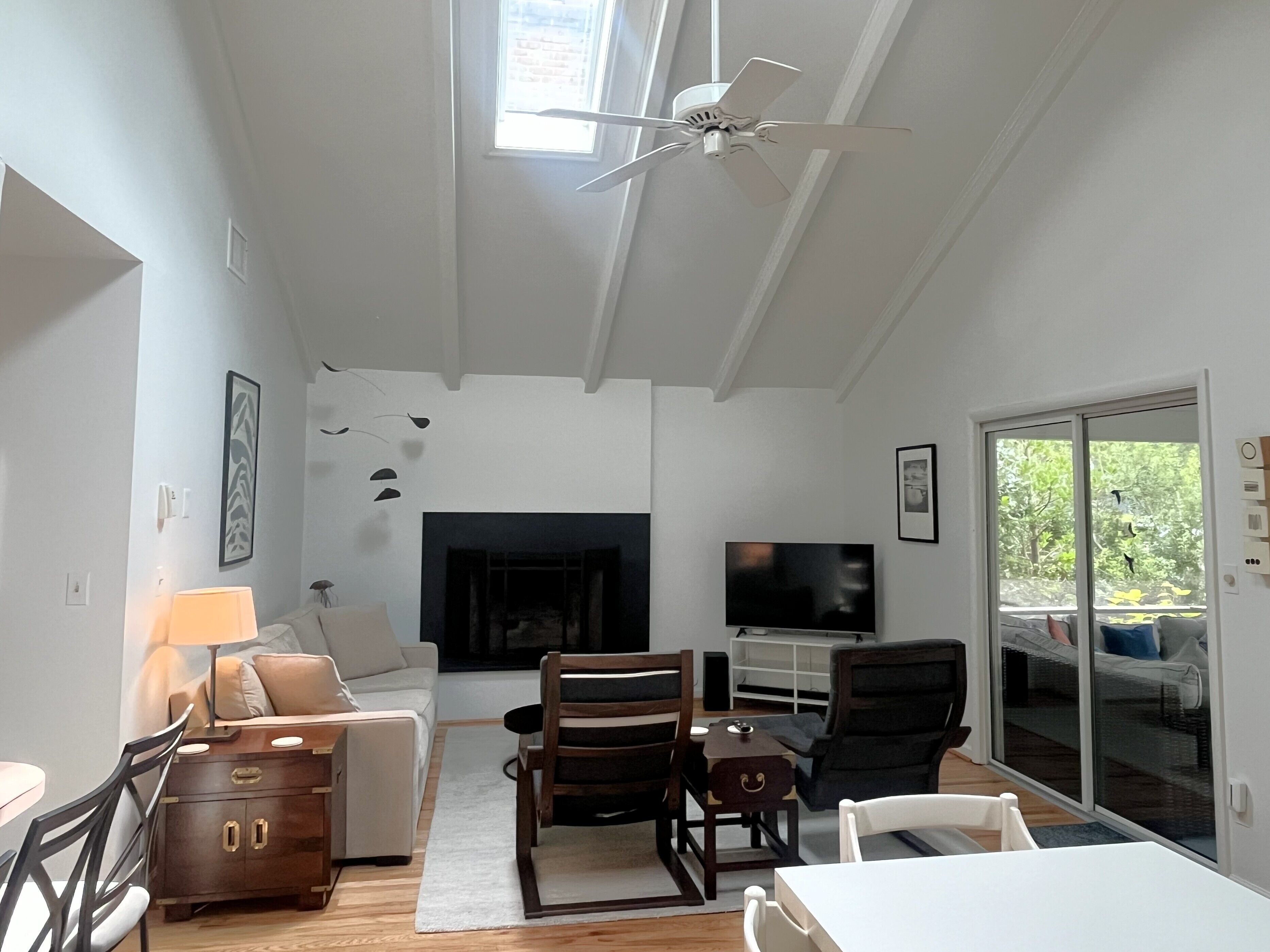 Ein Wohnzimmer mit Kamin, Fernseher und Deckenventilator.