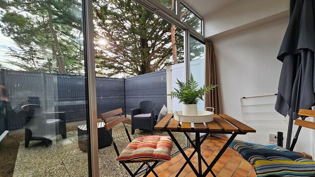 Un espace patio aménagé avec une table, des chaises et une plante en pot.