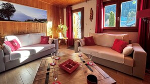 Een gezellige woonkamer met twee banken, een salontafel en een schilderij van een berglandschap.