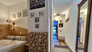 Um quarto acolhedor com cama de cabeceira de madeira, um painel rústico com toras e diversas fotos emolduradas.