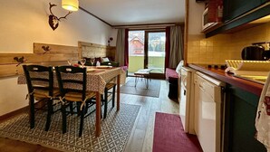 Uma cozinha acolhedora com mesa de jantar, cadeiras e luminária pendente.