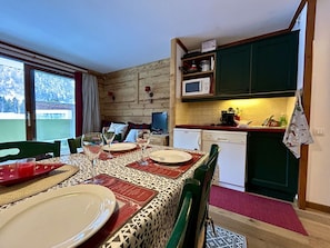 A dining area with a table set for four, a television, and a kitchen area with a microwave and a sink. - Studio cabin for 3 near slopes with parking La Salle-les-Alpes (La Salle-les-Alpes)