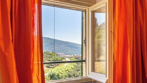 A window with a view of a hillside and buildings. - Cava Ardè Rooms:Garden view room, in the tranquility of Santa Giulia (Lavagna)