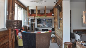 Ein gemütliches Interieur mit Schlafkoje, Fernseher und Essbereich.