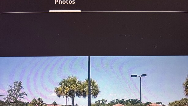 A tennis court with a net, palm trees, and a fence. - Spacious 2 bedroom 2 bathroom  condo in golf and tennis community (Bradenton)