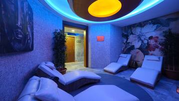 Ein Wellnessbereich mit Massagesesseln, einer Rezeption und einem Wandgemälde.
