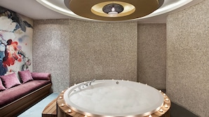 A modern bathroom with a freestanding bathtub, mosaic walls, and a wooden bench. - Hiper Suites Residance  (Antalya)