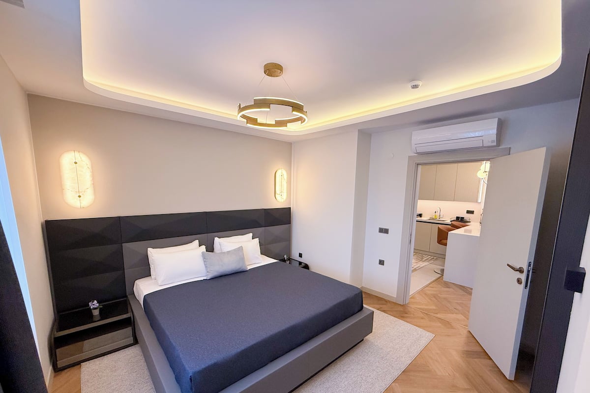 Un dormitorio moderno con una cama grande, mesitas de noche y un armario empotrado.