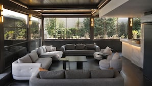 A modern living room with a sectional sofa, a coffee table, and a kitchen area with a marble countertop. - Hiper Suites Residance  (Antalya)