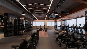 A modern gym with weightlifting equipment, treadmills, and a large window. - Hiper Suites Residance  (Antalya)