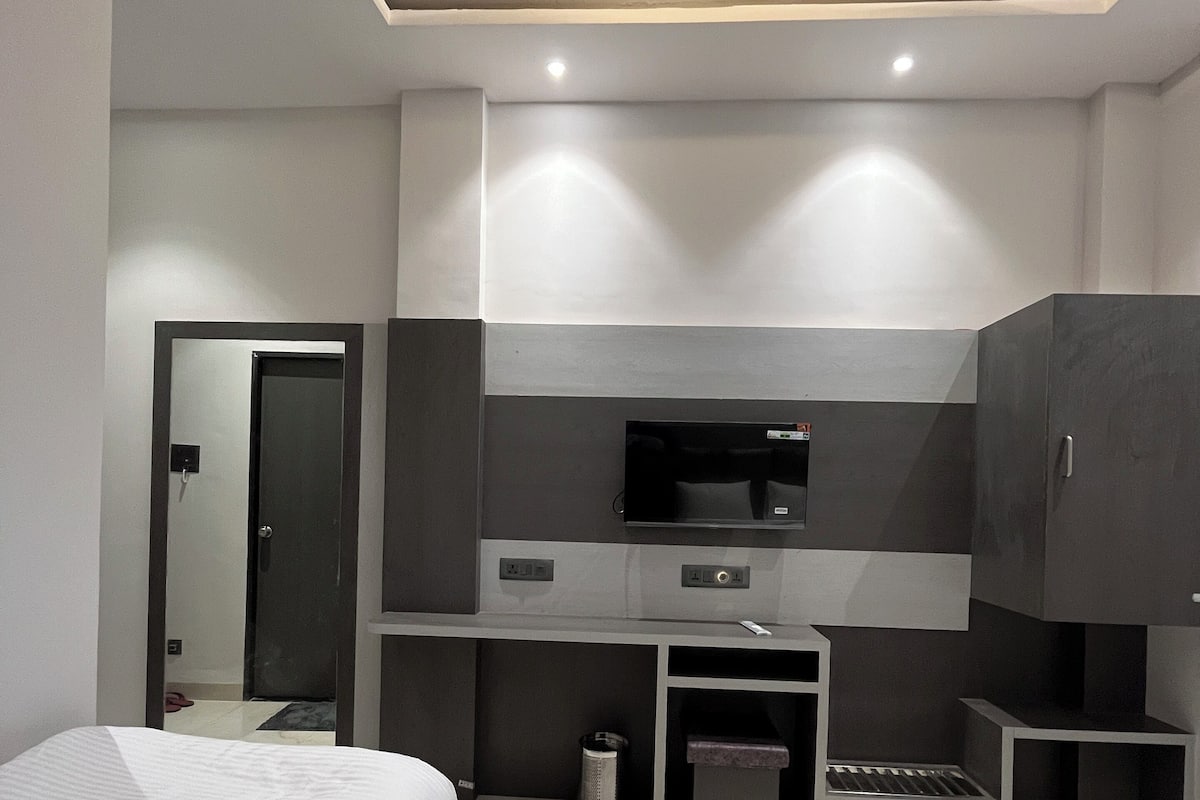 Une chambre d’hôtel moderne équipée de deux lits, d’un téléviseur à écran plat, d’un bureau et d’une armoire.