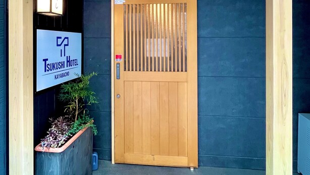 A wooden entrance with a sign for Tsukushi Hotel in Kayabacho. - KAYABACHO TSUKUSHI HOTEL (Tokyo)
