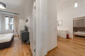 Ein Schlafzimmer mit einem Bett, einem Schreibtisch, einem Stuhl, einem Kleiderschrank und einem Fenster.