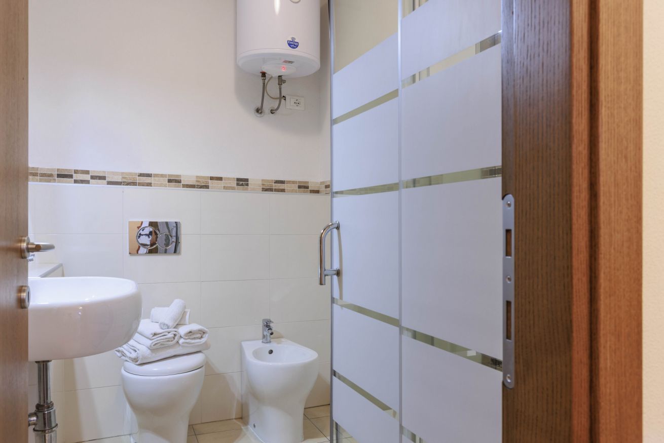 Une salle de bain équipée d’un lavabo, de toilettes, d’un bidet et d’un porte-serviettes.