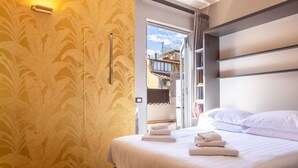 A hotel room with a bed, a door leading outside, and a patterned wall. - Ponte Vecchio Terrace Suite with Jacuzzi (Florence)