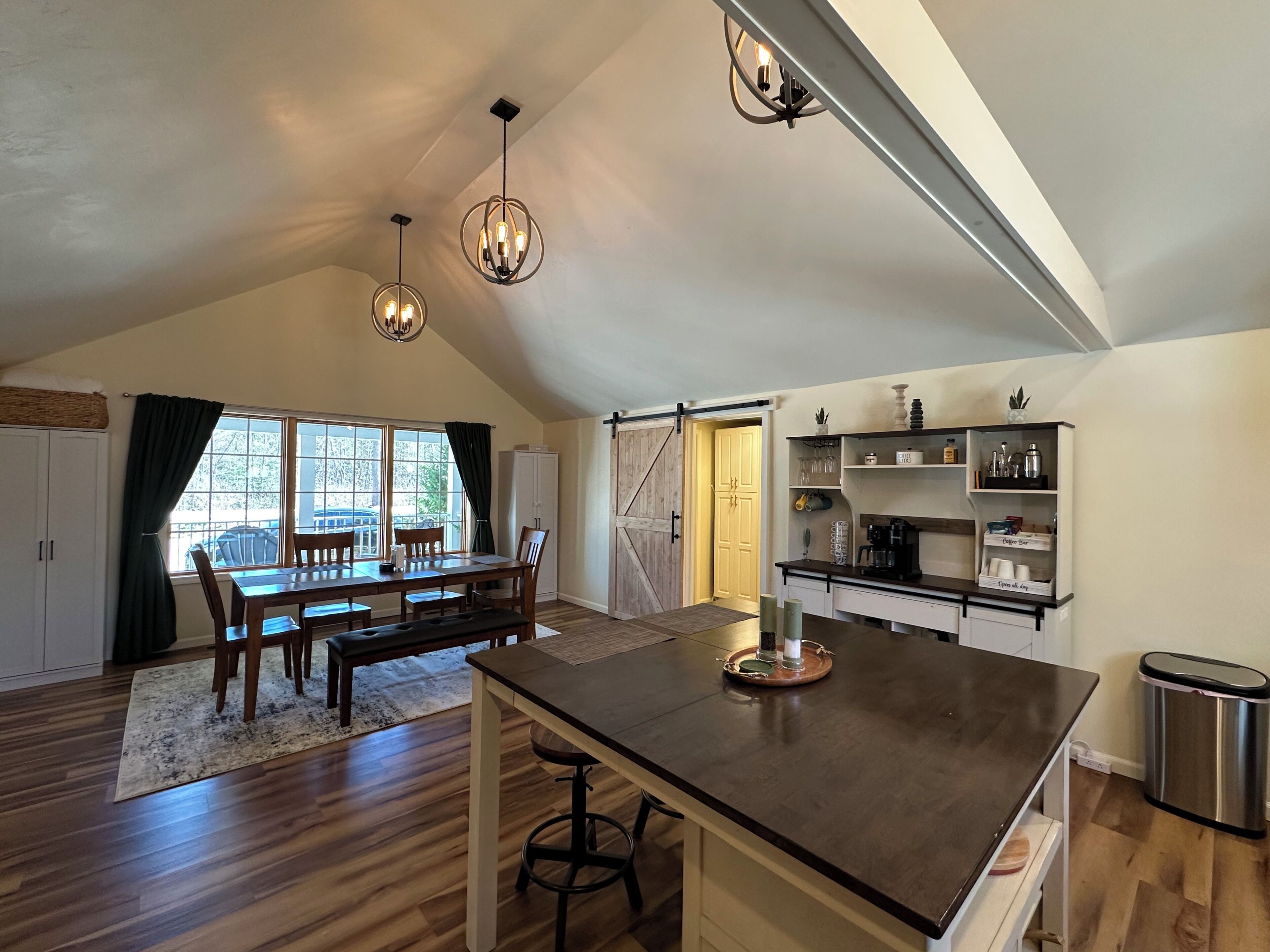 Un loft espacioso con comedor, cocina y un amplio ventanal que proporciona luz natural.