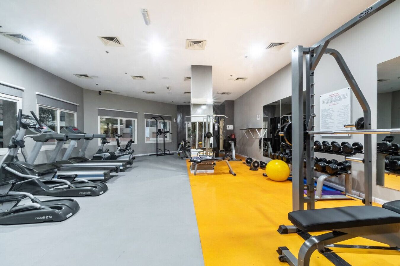 A gym with treadmills, weight machines, and free weights.