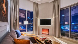 Ein modernes Wohnzimmer mit einer Couch, einem Couchtisch und einem an der Wand befestigten Fernseher.