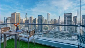 Ein Balkon mit Tisch und Stühlen mit Blick auf eine Skyline aus Hochhäusern und einen Fluss.