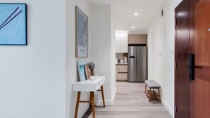 A modern hallway with a white console table, a bench, and a door. - Family & Group Friendly,  Near Beach Metro & Marina (Dubai)