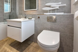 A modern bathroom with a white vanity, a toilet, and a shower area. - 2 Bed in Abersoch (oc-pendui) (Abersoch)