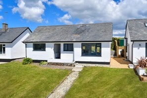 A row of white cottages with grey roofs, a stone pathway, and a grassy lawn. - 2 Bed in Abersoch (oc-pendui) (Abersoch)