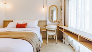 Una camera d'hotel moderna con un letto, una scrivania, una sedia e un'ampia finestra con tende.