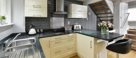 Een magnetron, een oven, een vaatwasser, kookgerei, borden en bestek