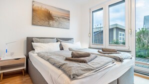 Una camera da letto moderna con un letto grande, comodini, un tavolino e una finestra vista esterna.