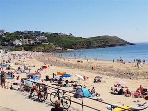 A crowded beach with people sunbathing and swimming, tents, and bicycles. - 4 Bed in Mumbles (oc-hh53) (The Mumbles)