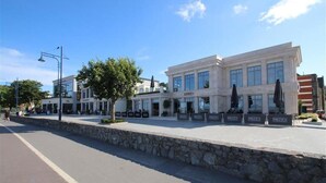 A modern building with a stone facade, large windows, and outdoor seating areas. - 4 Bed in Mumbles (oc-hh53) (The Mumbles)
