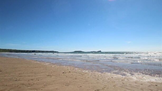 A beach with a clear sky and calm sea. - 1 Bed in Swansea (oc-hh404) (Llanmadoc)