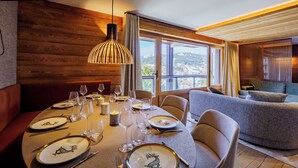 Un comedor con interior de madera, un amplio ventanal con vistas y una lámpara moderna.