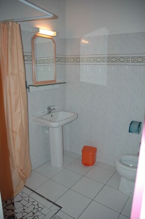Ein Badezimmer mit Waschbecken, Toilette und Duschvorhang.