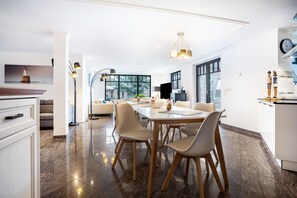 Une cuisine moderne avec un coin repas, de grandes fenêtres et une vue sur la ville.