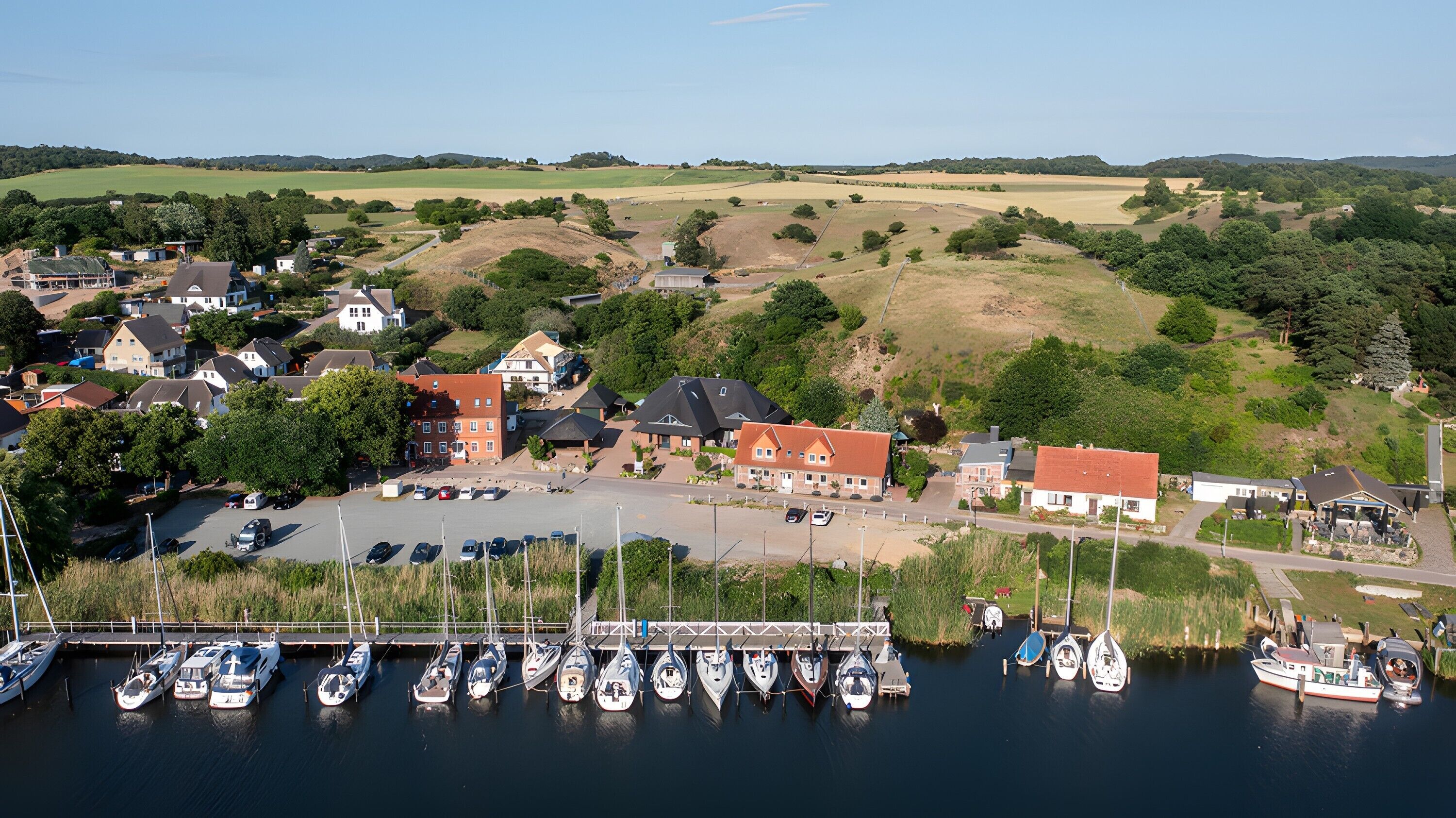 A marina with boats docked, surrounded by residential buildings and greenery.