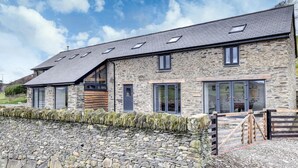 A stone building with a sloped roof, large windows, and a stone wall. - 2 Bed in Machynlleth (oc-bow39) (Darowen)