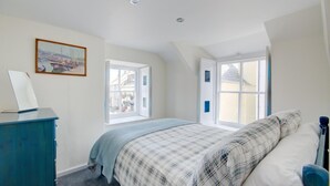 A bedroom with a bed, a desk, and two windows. - 2 Bed in West Looe (oc-l30054) (Looe)