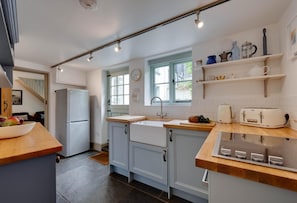 Eine moderne Küche mit Backofen, Spüle und Fenster.
