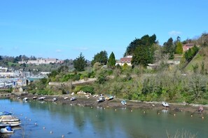 A coastal area with boats docked along the shore, a marina in the background, and buildings on a hillside. - 4 Bed in Kingswear (oc-bc59) (Dartmouth)