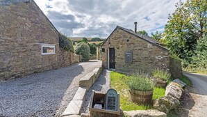 Un bâtiment en pierre avec un chemin de gravier menant à une porte sur laquelle est inscrit le mot « Œufs ».