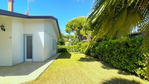 Un edificio bianco con ingresso in tegole e un camino ben visibile.