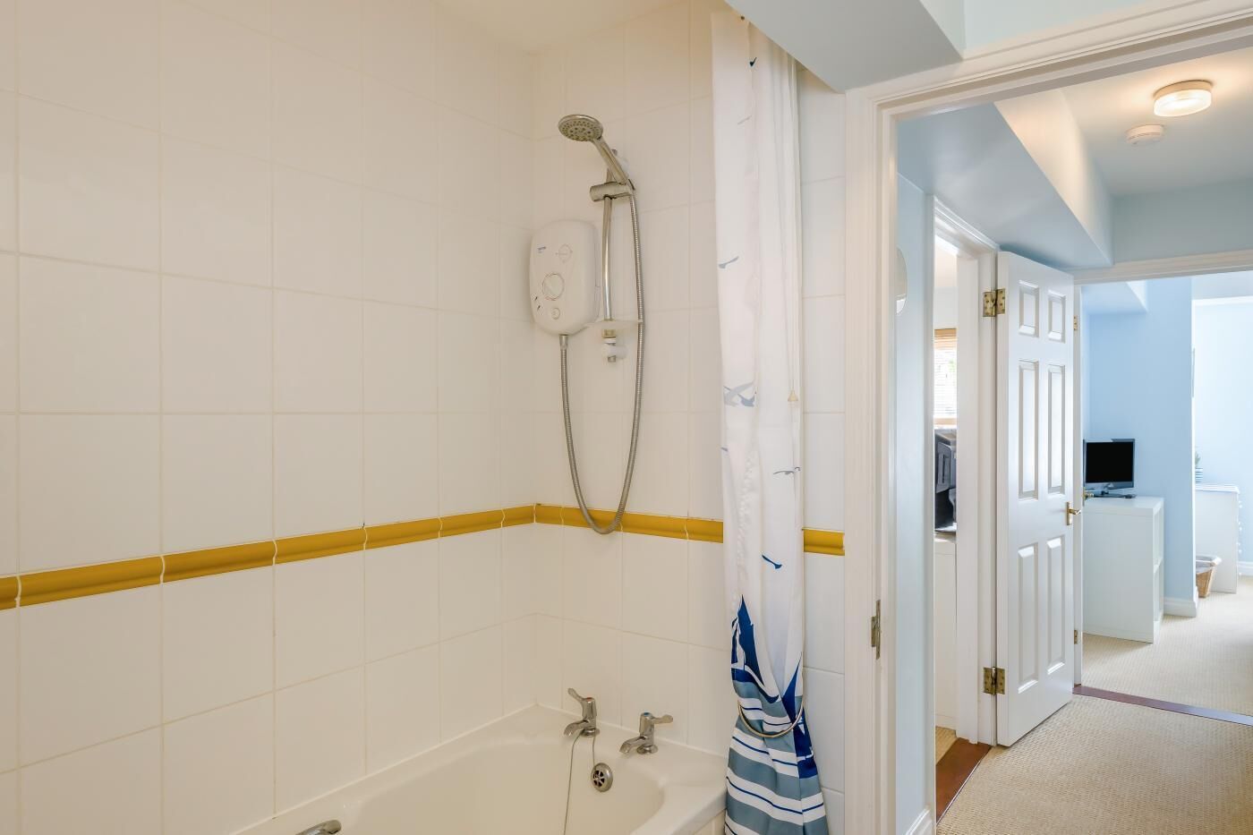 Ein Badezimmer mit Badewanne, Dusche und einem Handtuch an der Wand.